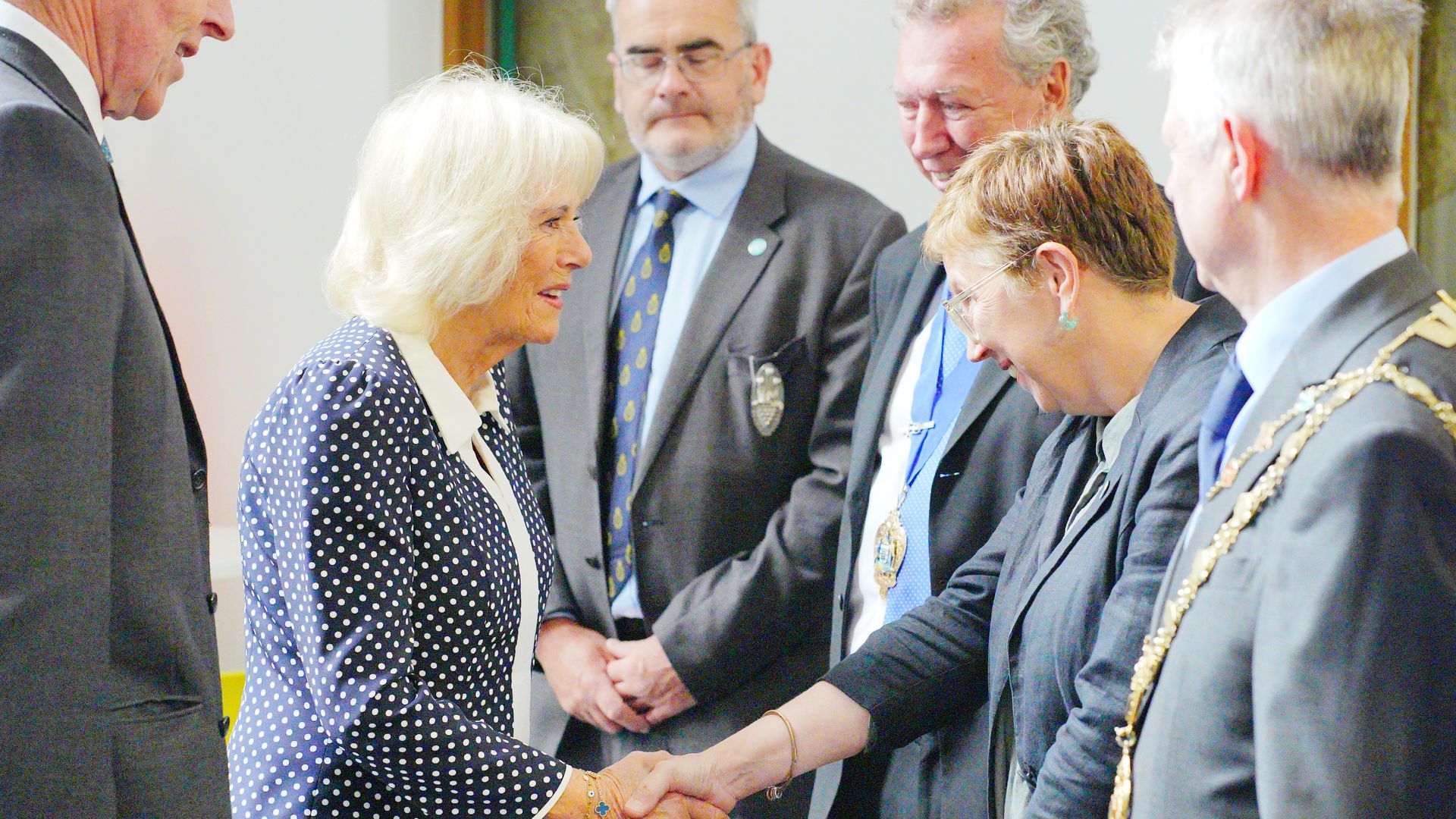 Queen Camilla shaking hands with a lady