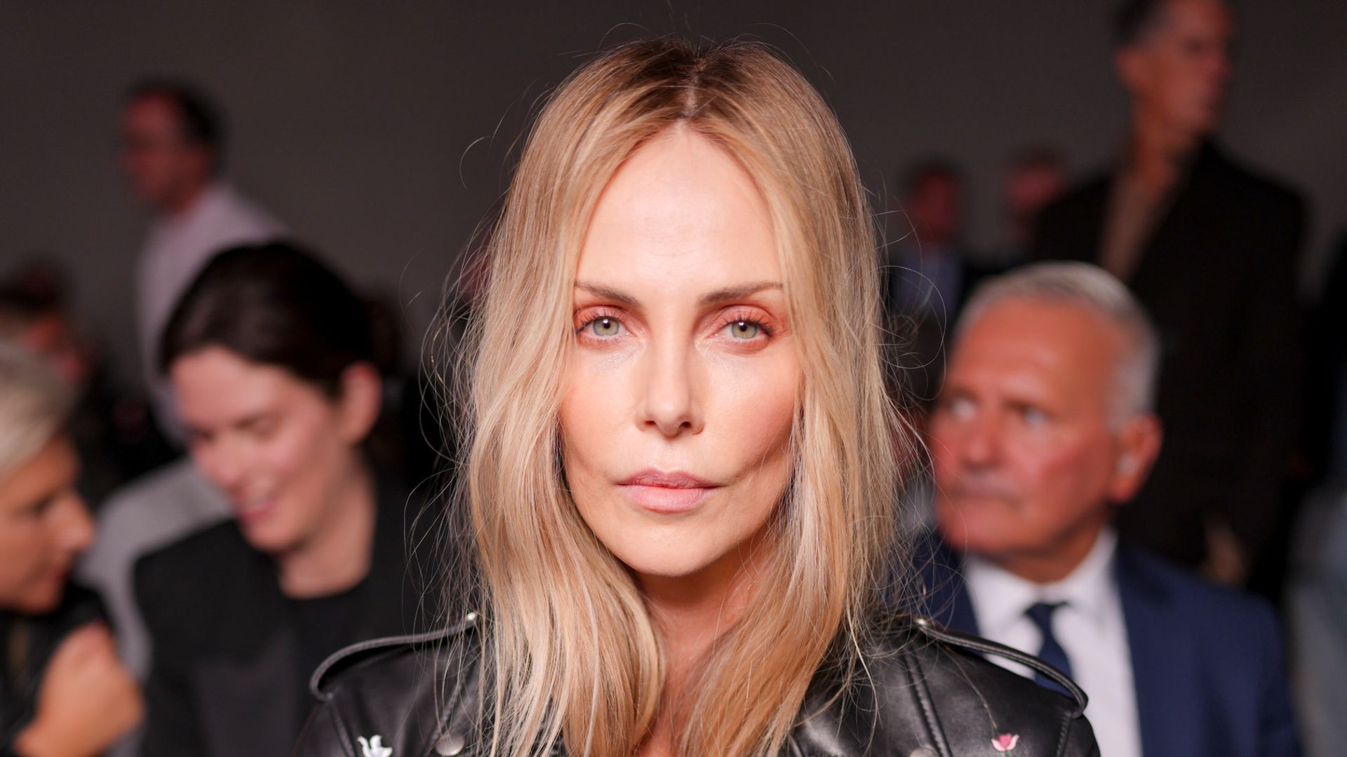 Charlize Theron opts for nothing under her biker jacket for bold fashion week appearance