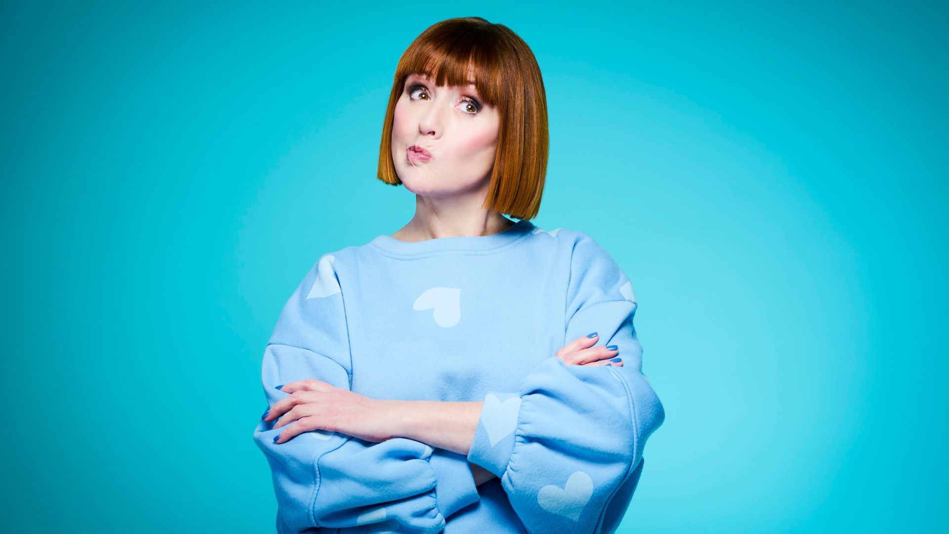 woman in a blue jumper pulling a face