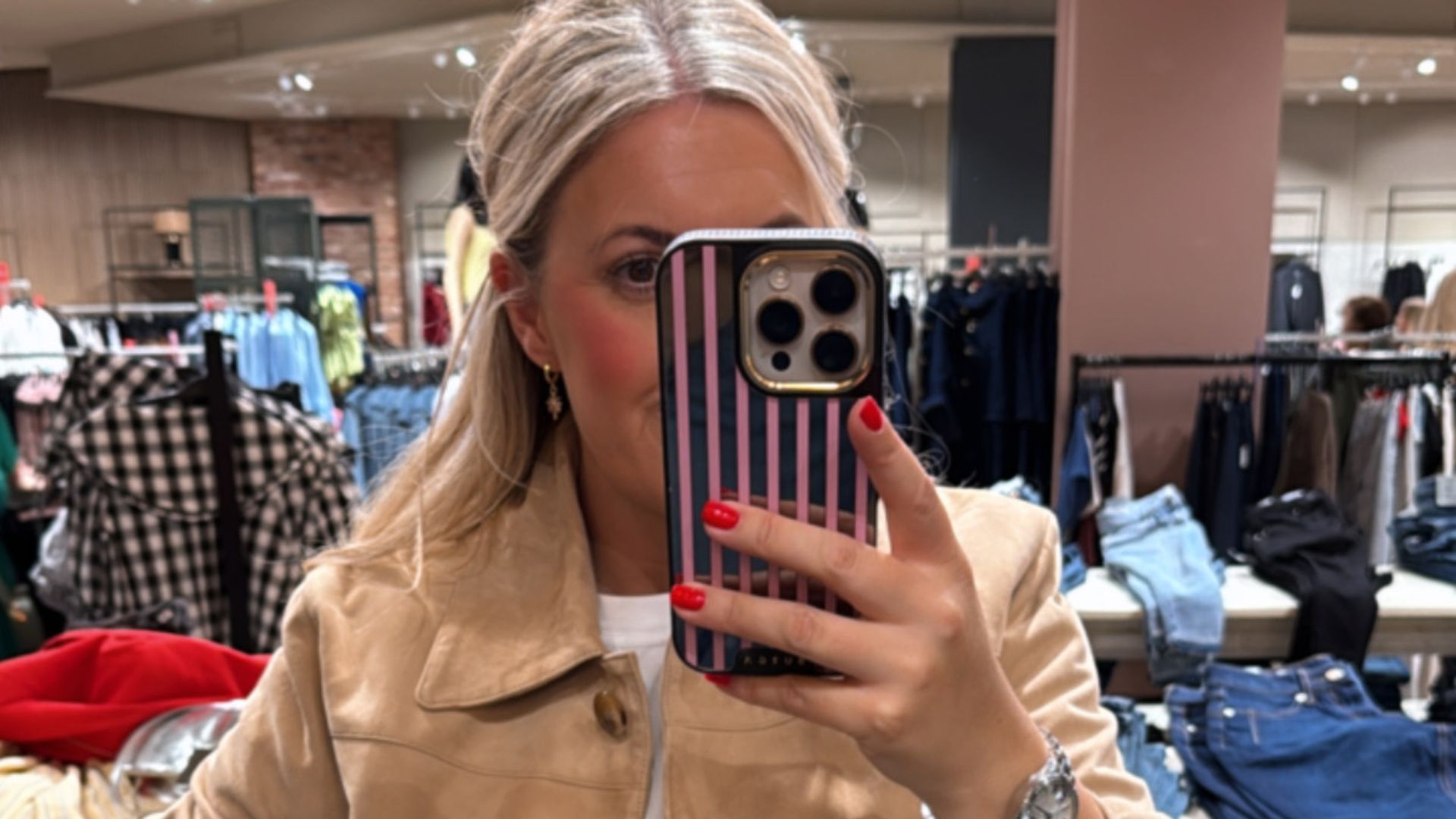 Shopping editor Leanne Bayley wearing the River Island premium suede jacket posing in front of a mirror. She is styling it with jeans and a white t-shirt