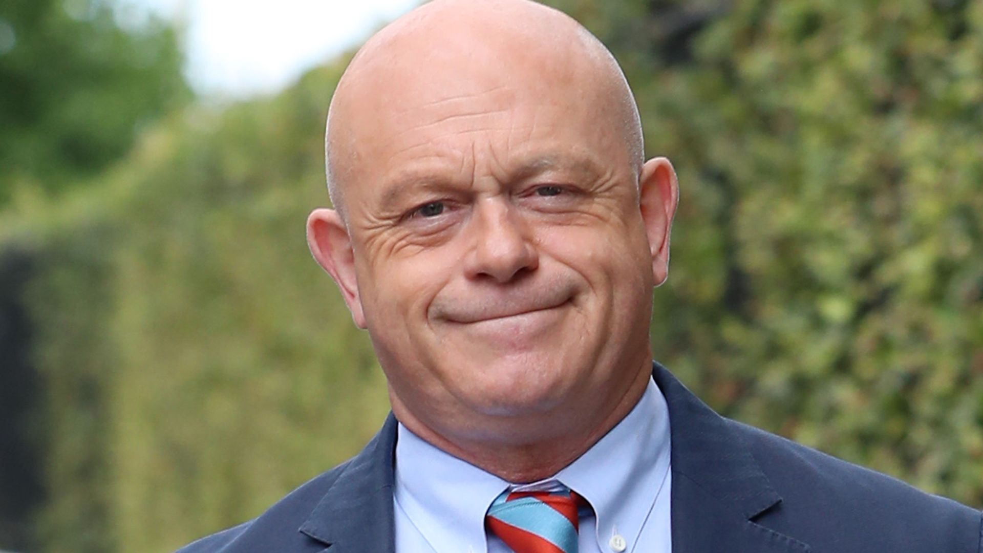 Ross Kemp in a blue suit jacket and striped tie outside