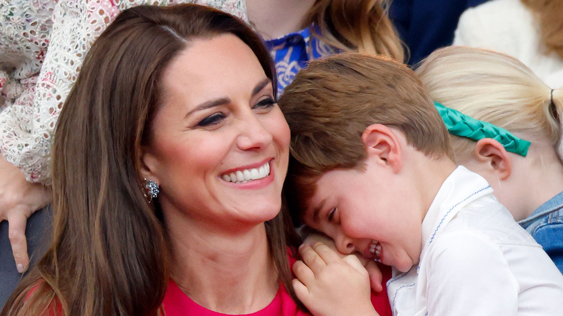 Catherine grinning with Prince Louis with head on her shoulder