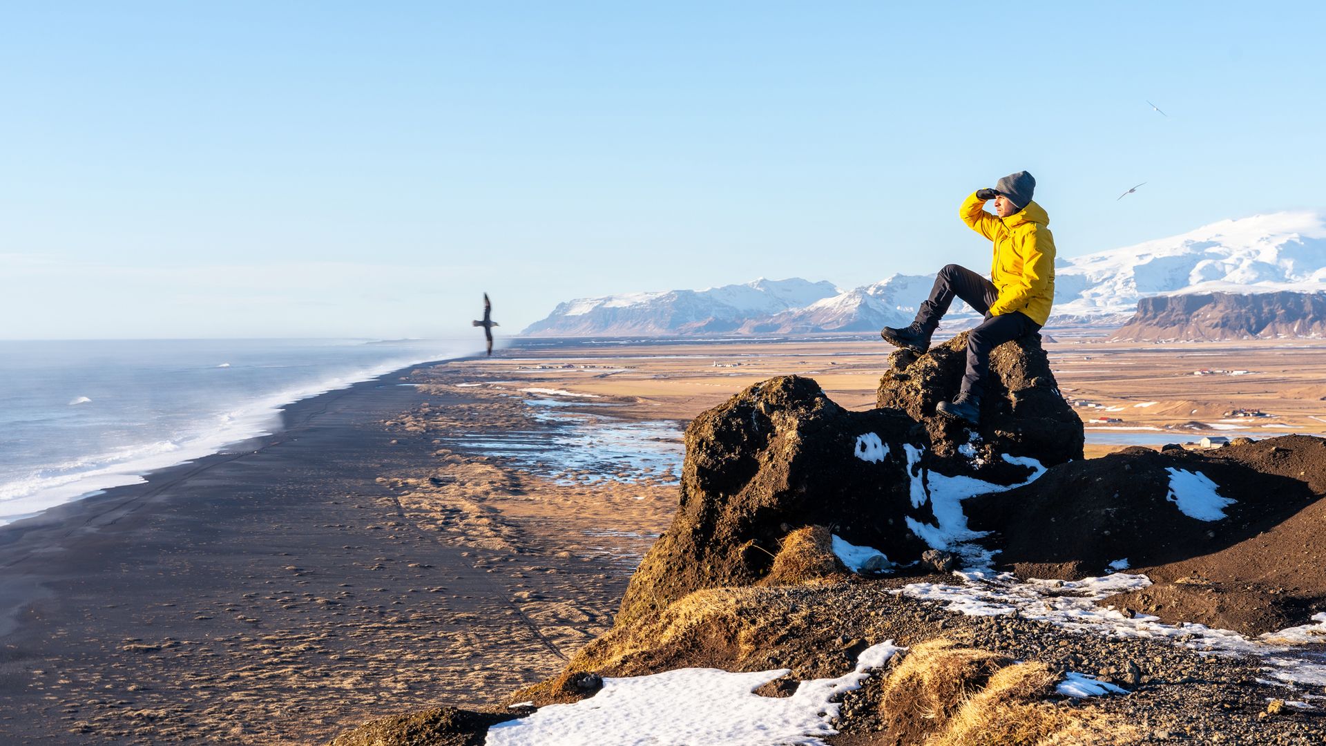 Man looking at the views of a sandy beach in winter