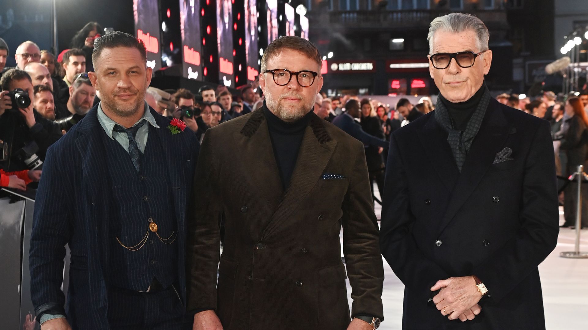 Tom Hardy standing with Guy Ritchie and Pierce Brosnan