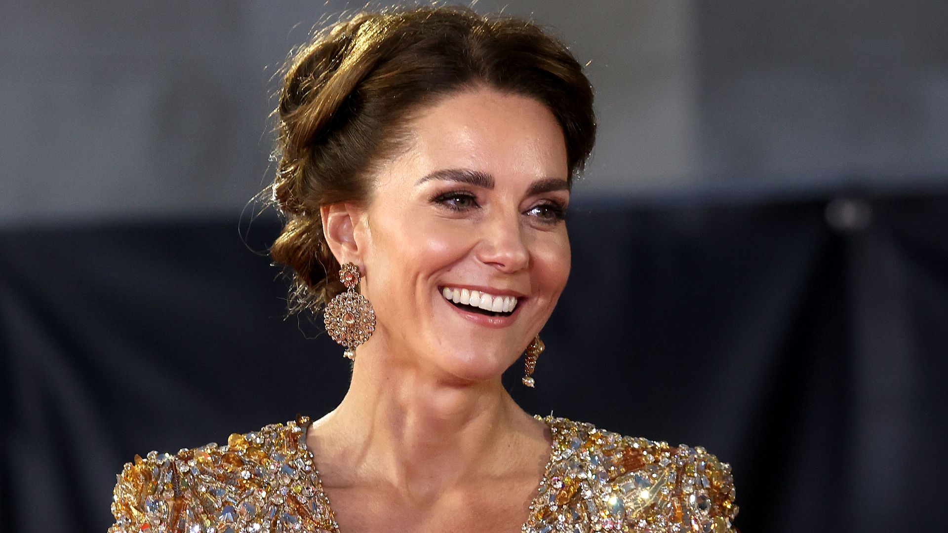 Princess Kate smiling in a gold sparkly dress