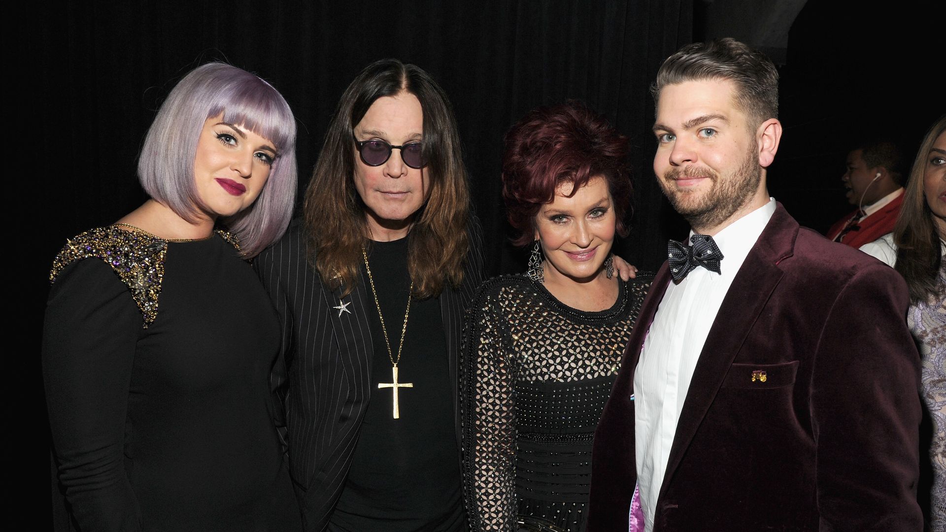 Kelly Osbourne posing with Ozzy, Sharon and Jack Osbourne
