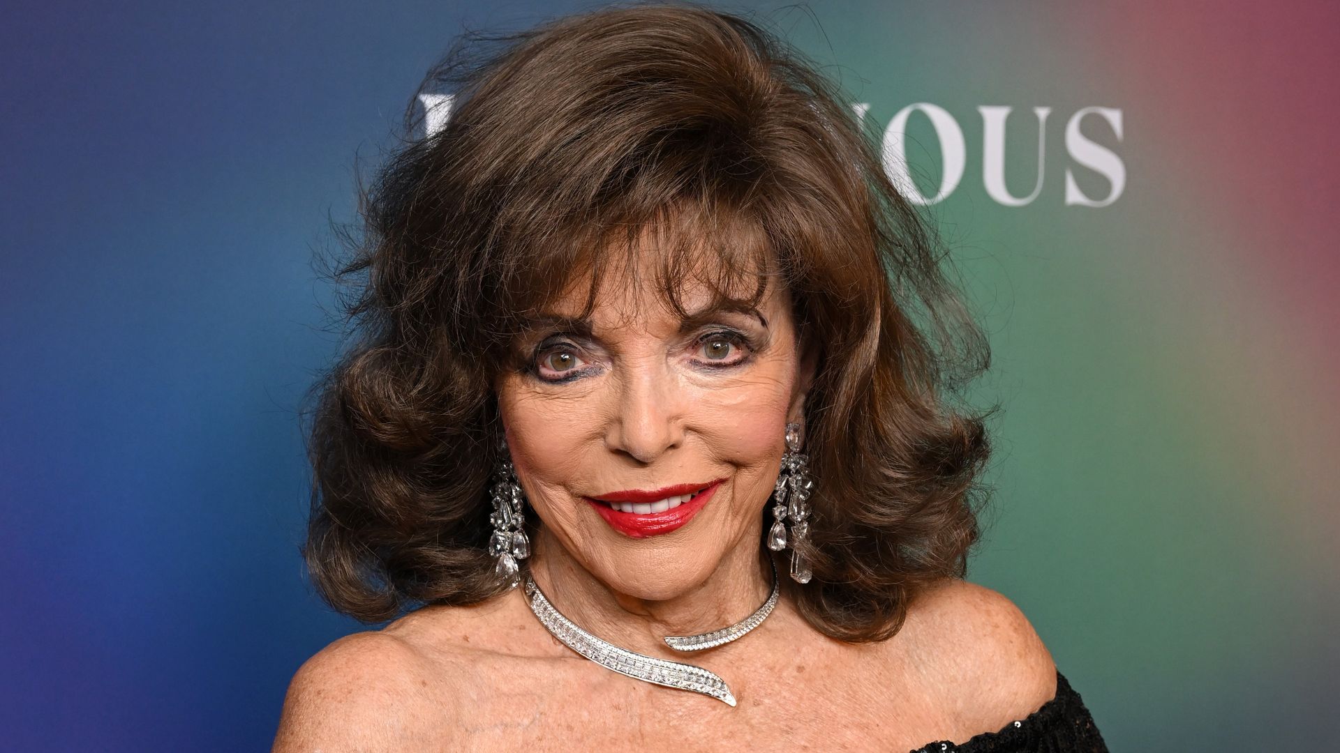 Joan Collins's mother-of-the-groom entrance in caped look