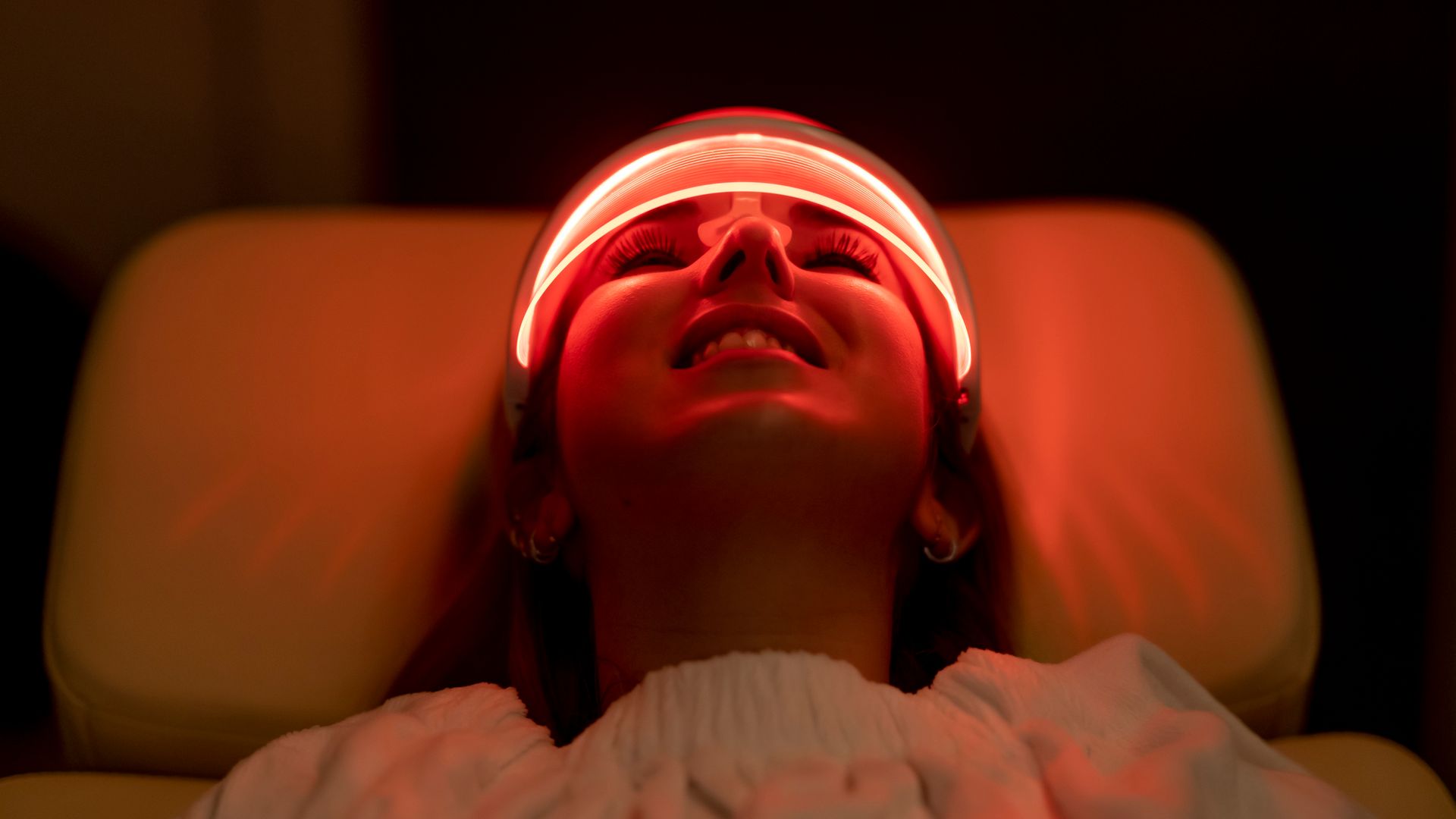 Close-up of woman wearing medical led regeneration mask in wellness and care room