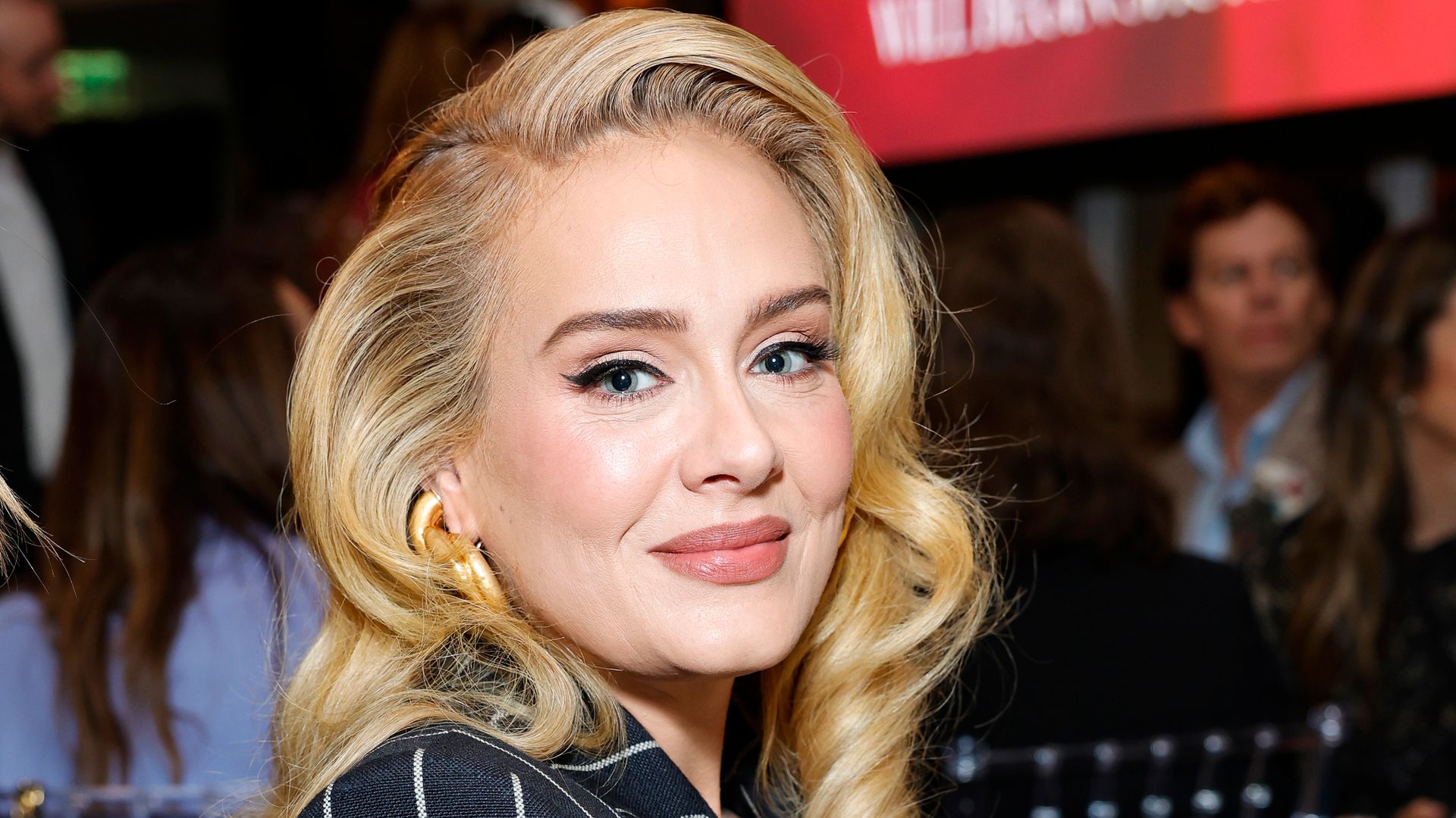 Adele side on in a striped suit