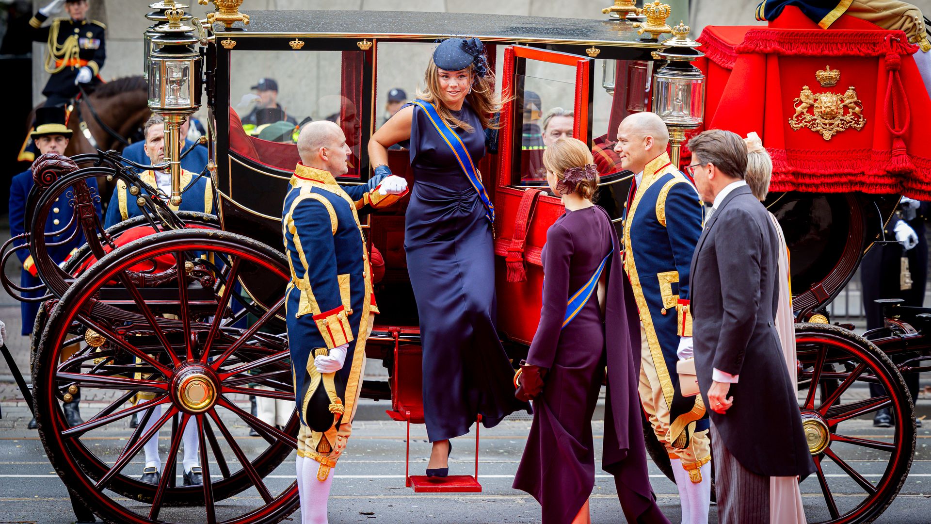 Princess Ariane being helped out of a carriage as Princess Alexia looks on
