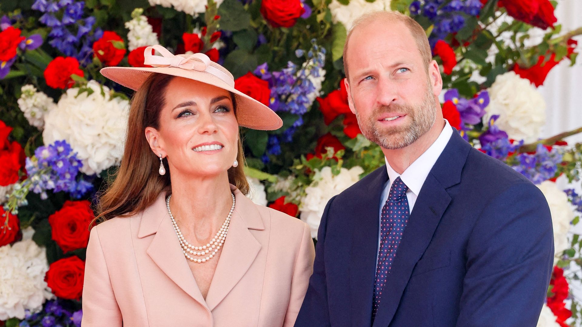 woman and man in formal wear against floral backdrop