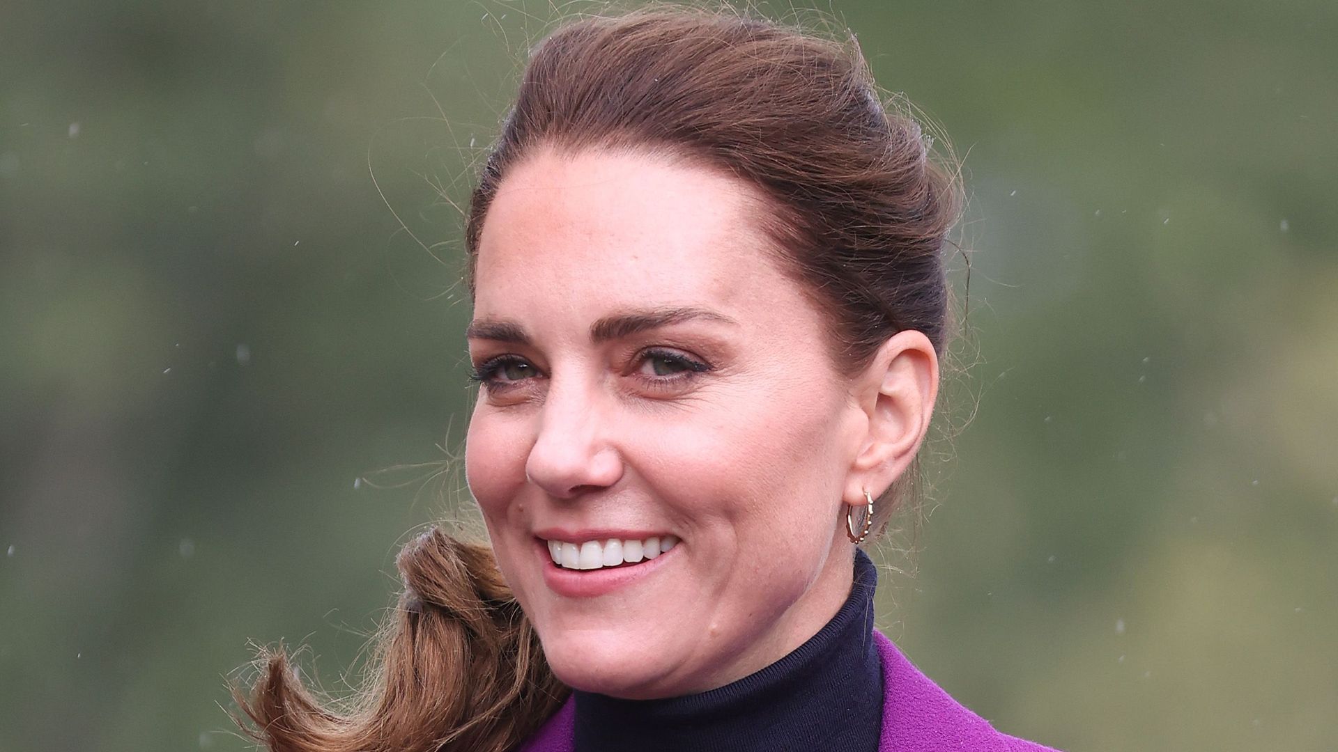 Catherine in a purple suit and navy sweater