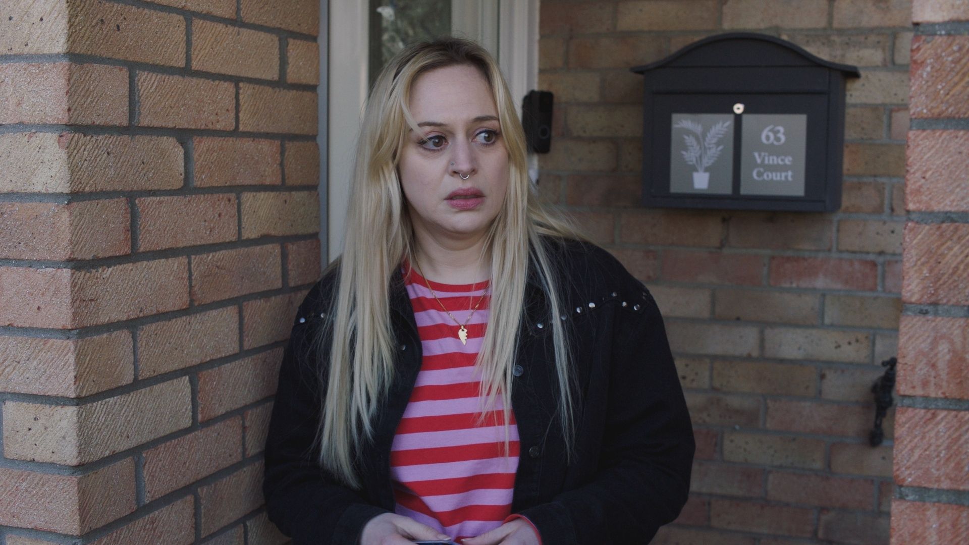 Sammy T. Dobson as Nicole Piper in Casualty standing in front of a house