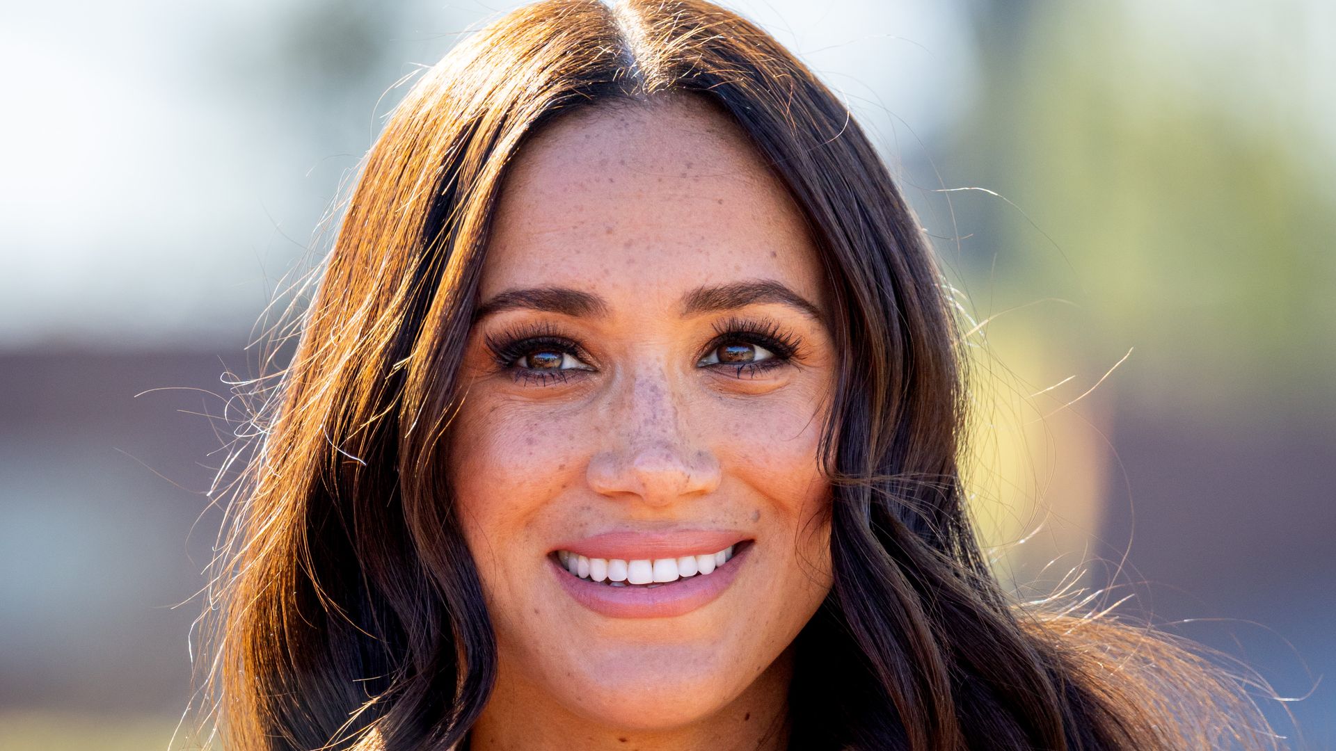 Meghan, Duchess of Sussex smiling in cream blazer