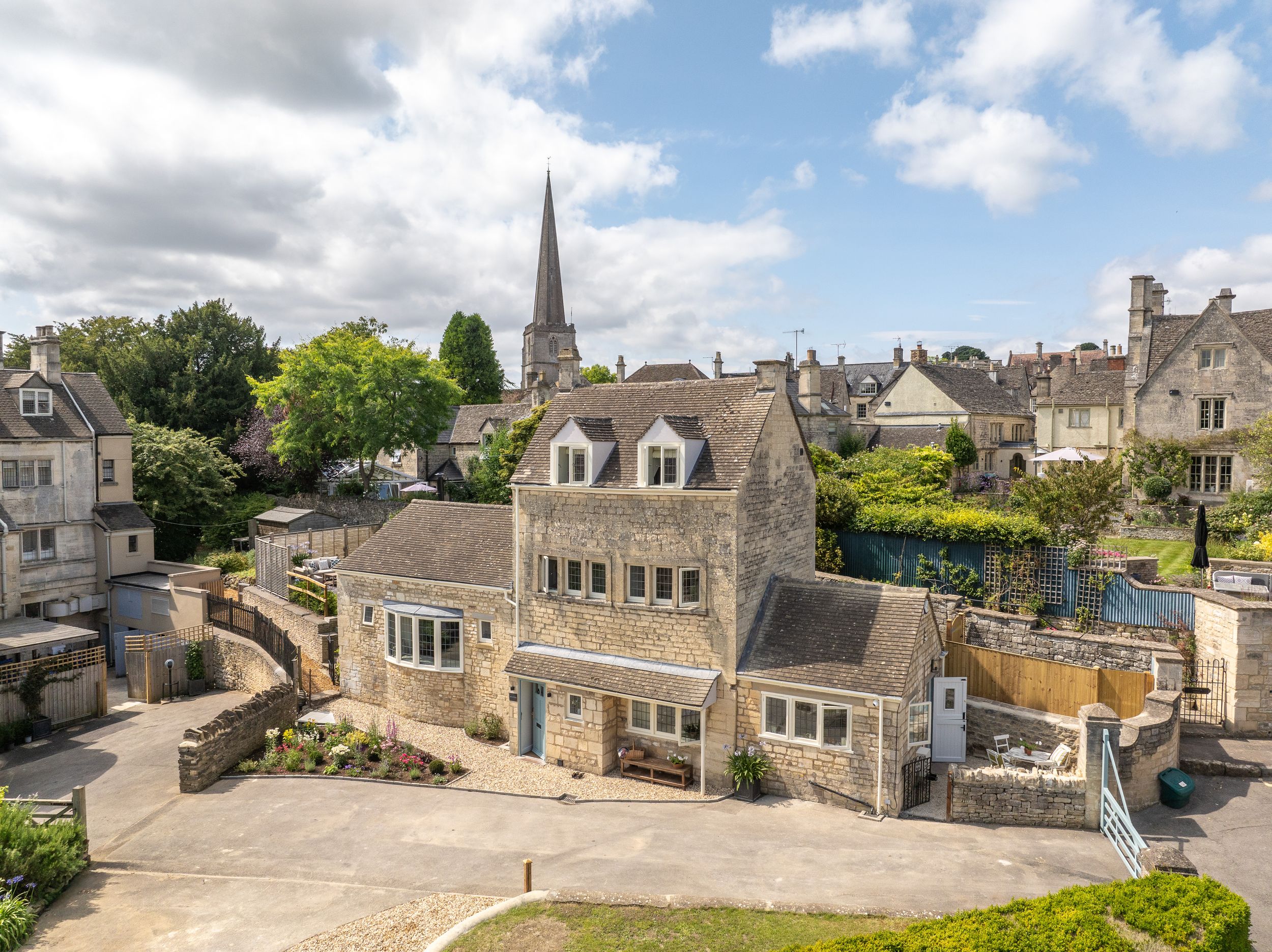 a picturesque cotswold village with blue skies and a steeple