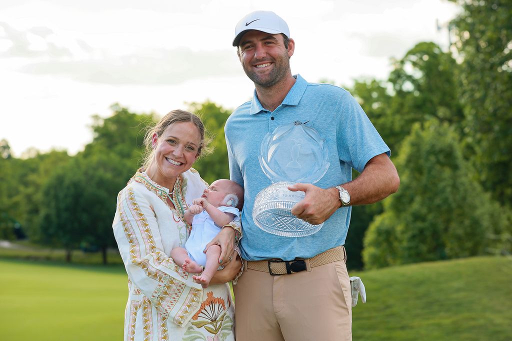 Scottie Scheffler of Dallas, Texas holds the winners trophy and his wife Meredith and son Bennett during the awards ceremony after winning the Memorial Tournament presented by Workday at Muirfield Village Golf Club on June 9, 2024 in Dublin, Ohio