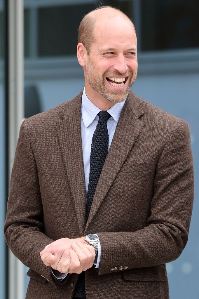 Prince William smiling in brown jacket