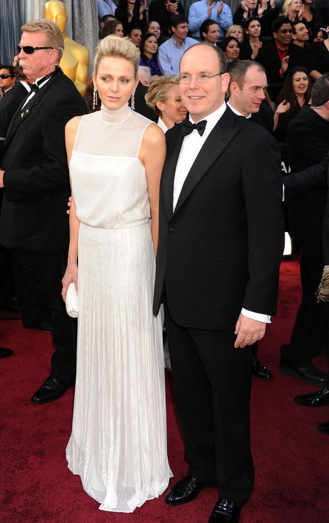 Princess Charlene in white dress and Prince Albert on red carpet 