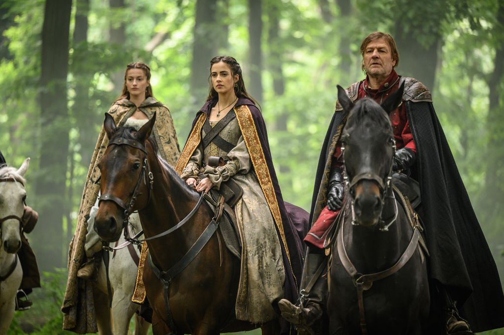 two women and man riding horses in woodland
