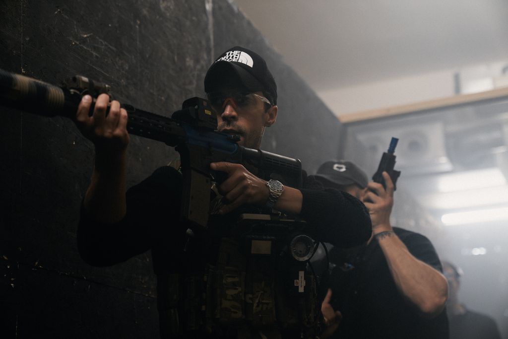 man in black cap holding gun