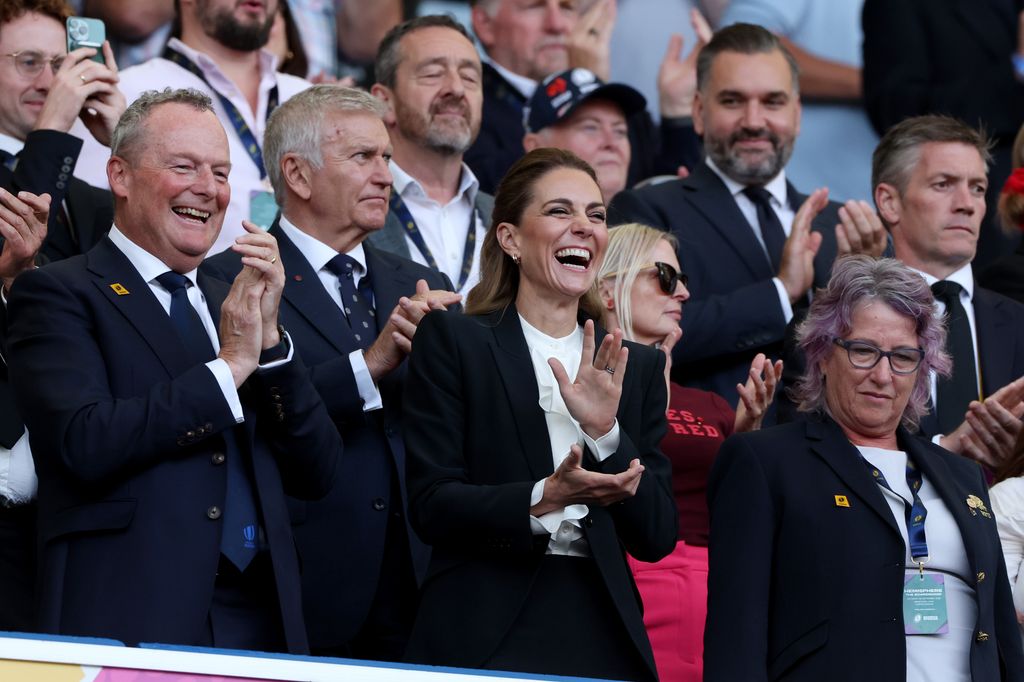 Kate Middleton laughing and applauding in a crowd