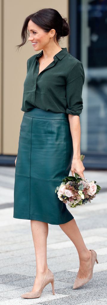 Meghan Markle dengan rok pensil hijau membawa bunga