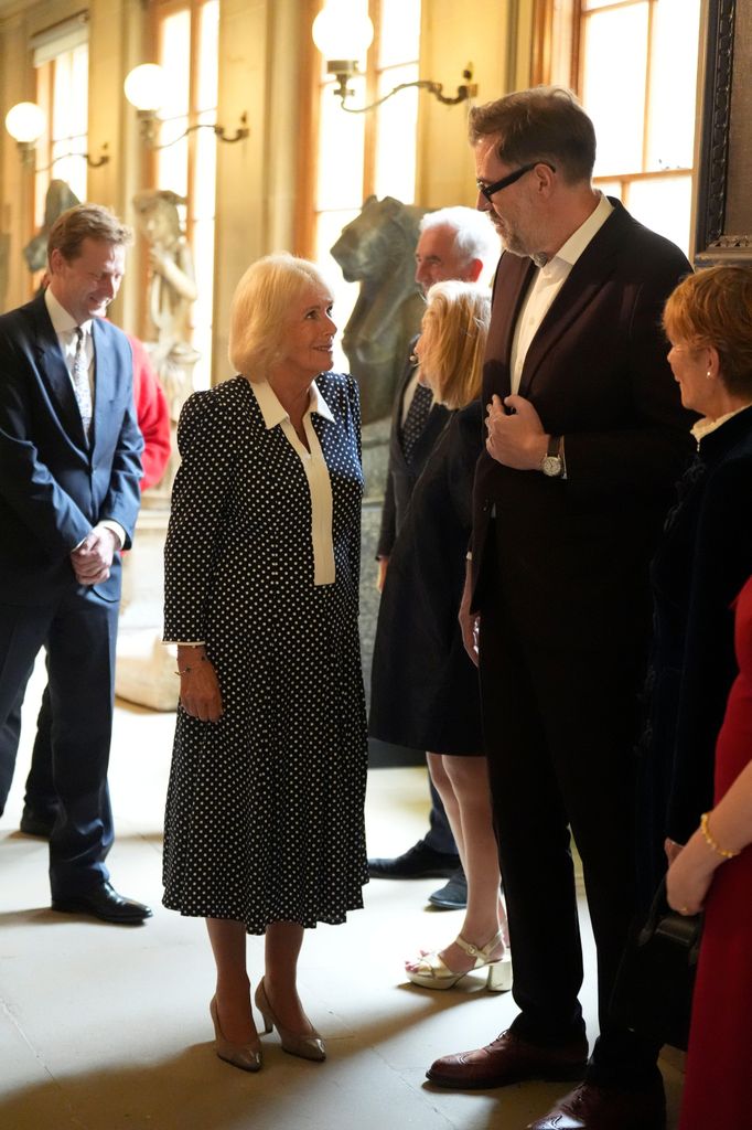 Queen Camilla looking up at Richard Osman