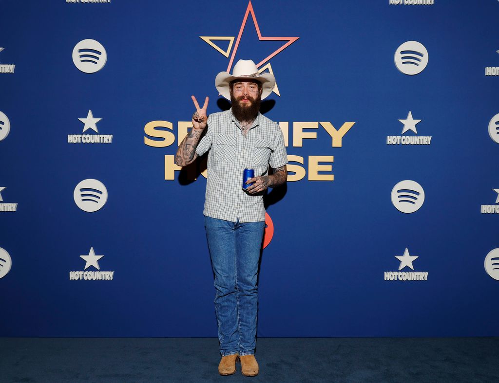 post malone wearing cowboy hat holding can and throwin gup peace signs