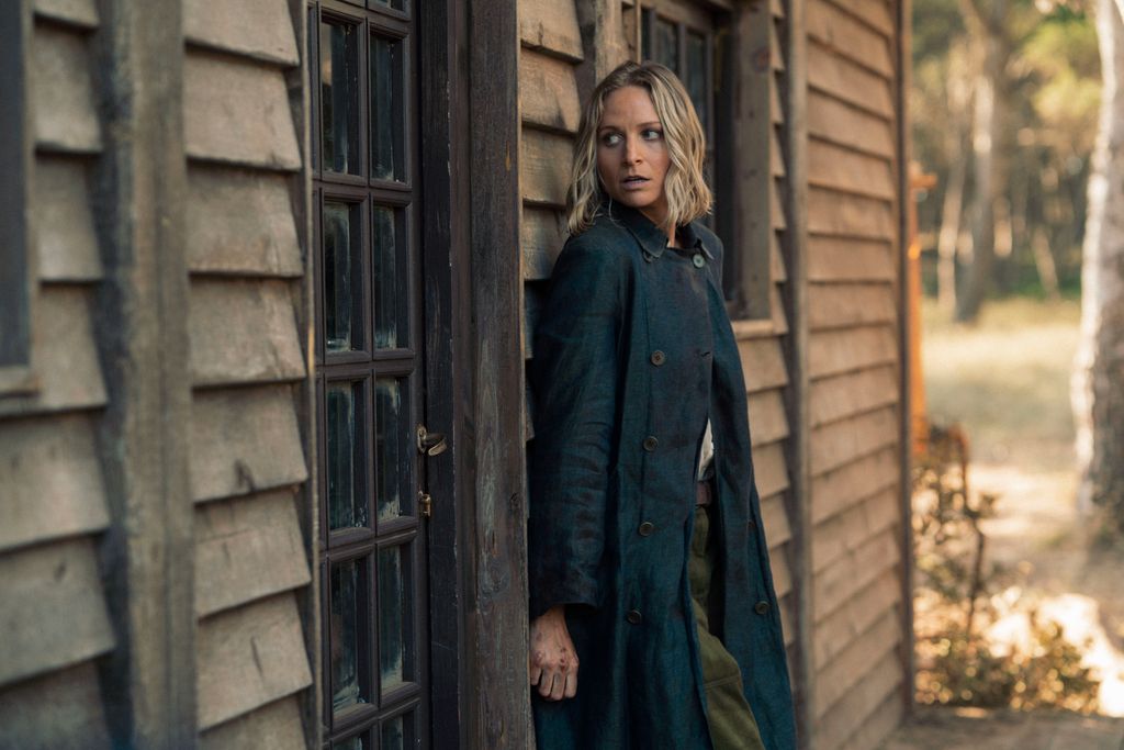 woman standing outside cabin 