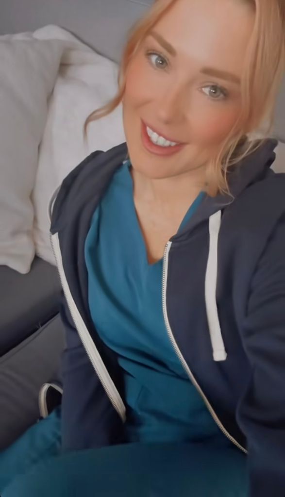 woman wearing blue scrubs sitting on sofa