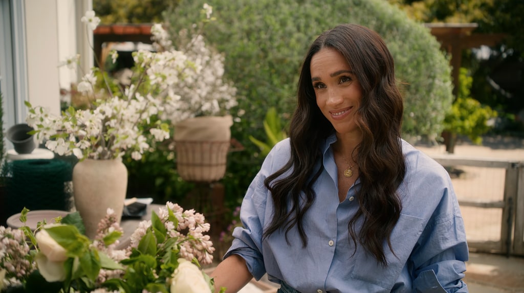 Meghan Markle wearing blue shirt and soft wavy long hairstyle