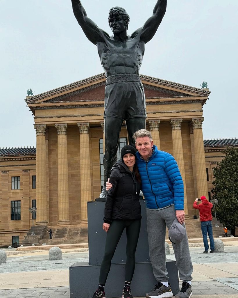Gordon Ramsay and his wife, Tana posing in front of a statue