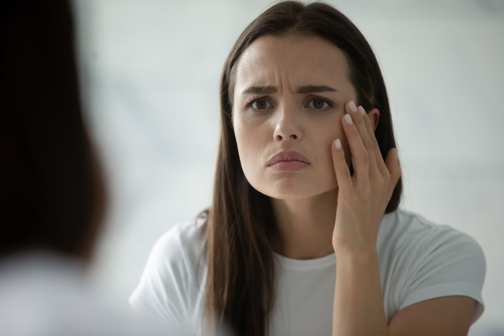woman in mirror stressed out.