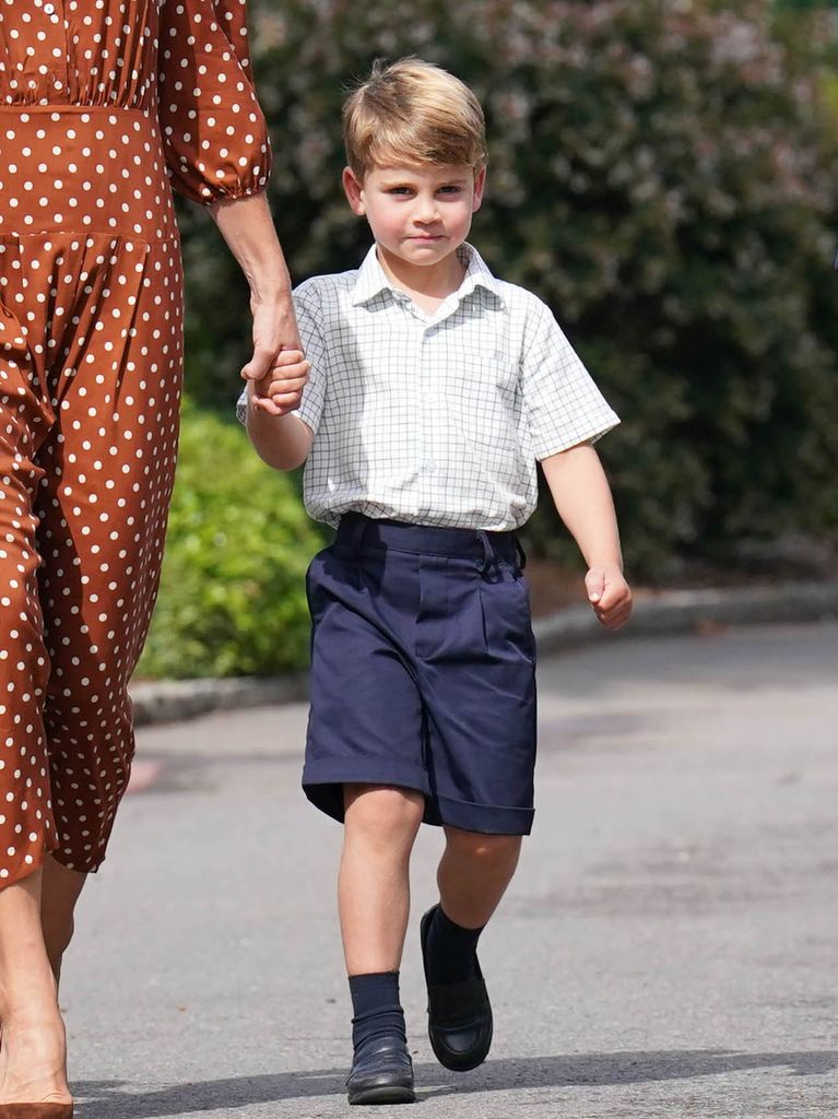 Prince Louis in shorts holding his mother's hand
