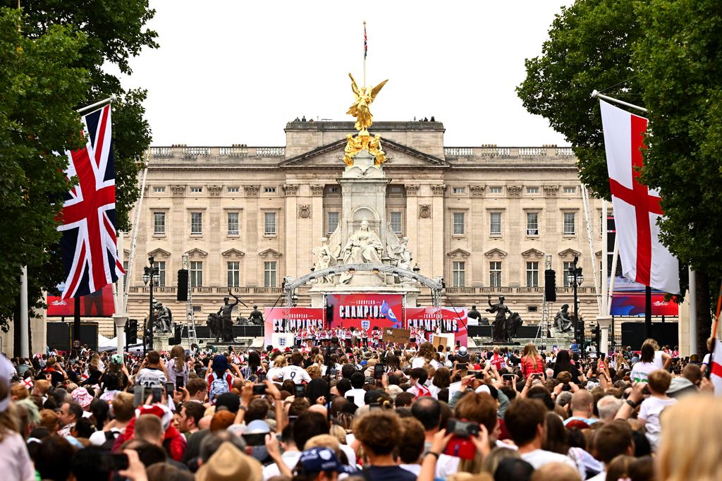 view of the stage at Buckingham Palace surrounded by crowd of people