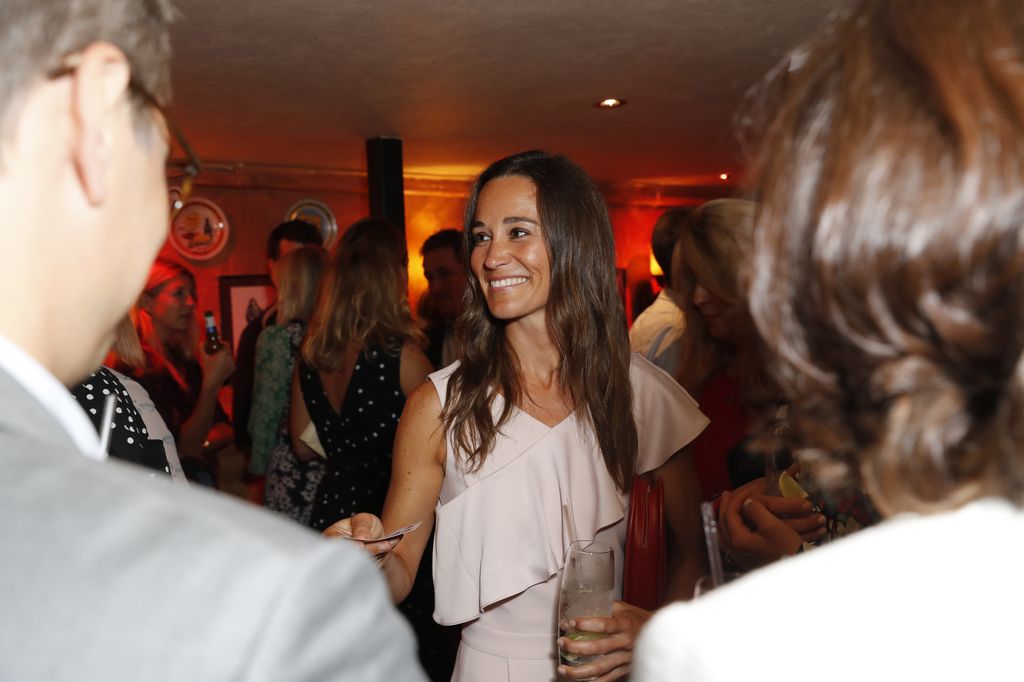 Pippa Middleton at party talking in group