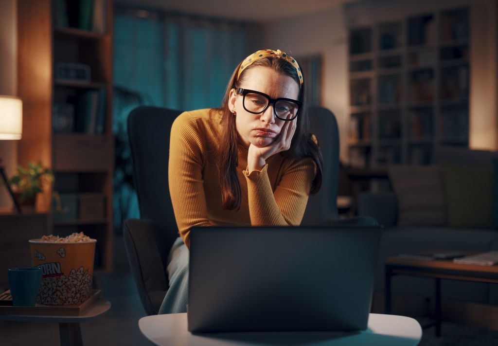 bored midlife woman looking at laptop screen
