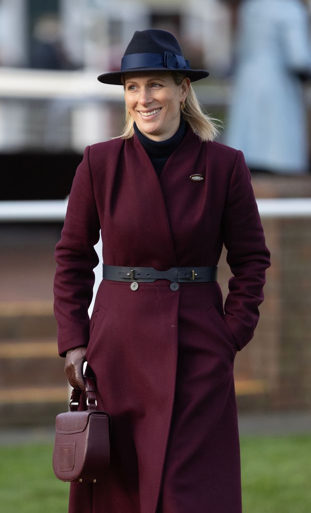 Zara Tindall berjalan dengan mantel merah marun