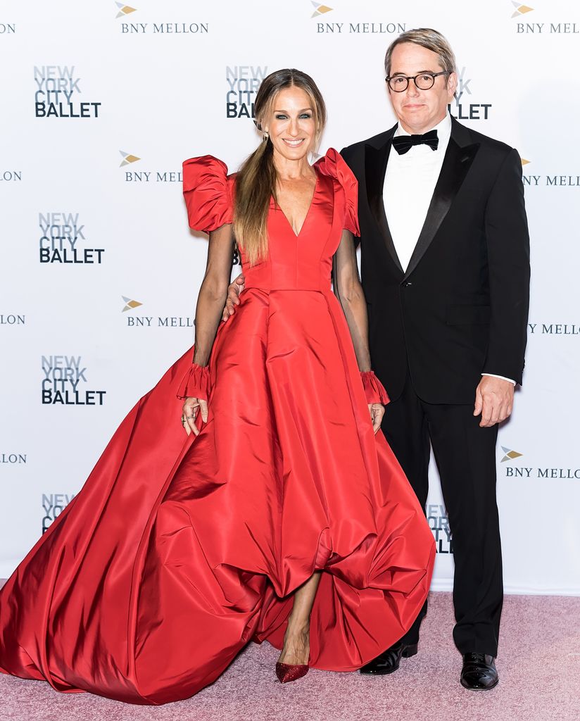 Sarah Jessica Parker dalam gaun merah ceri di samping Matthew Broderick dalam setelan jas