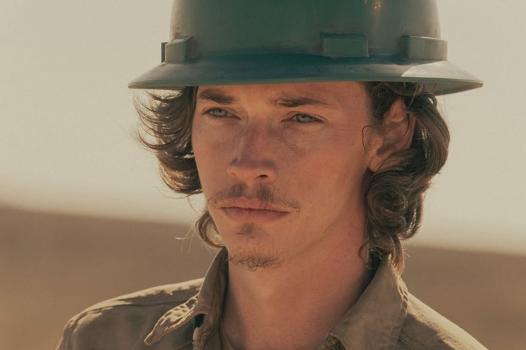 A man wears a green hard hat