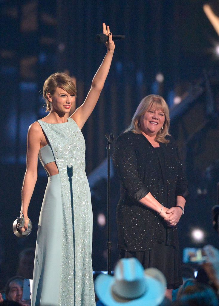 Taylor on stage celebrating with her mom beside her smiling proudly