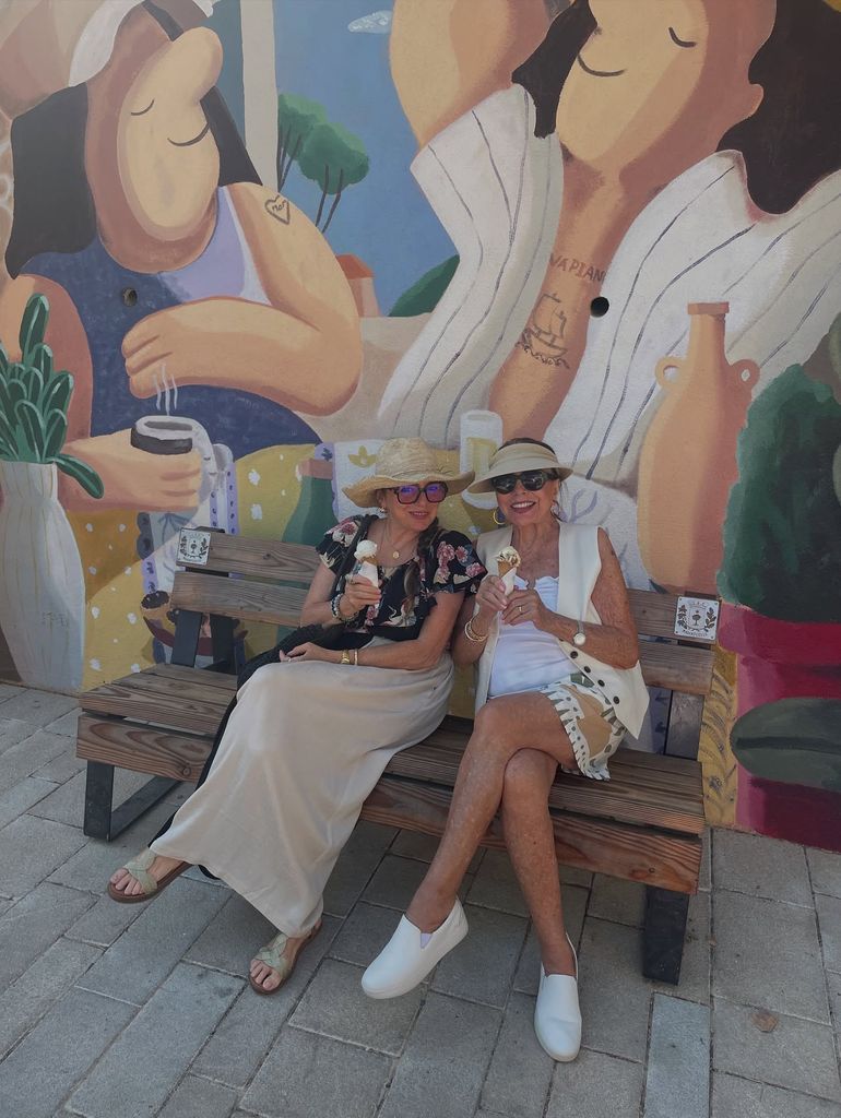 Joan sitting in mini shorts beside daughter eating ice cream