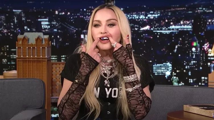 madonna pulling at mouth and showing off grills on talk show