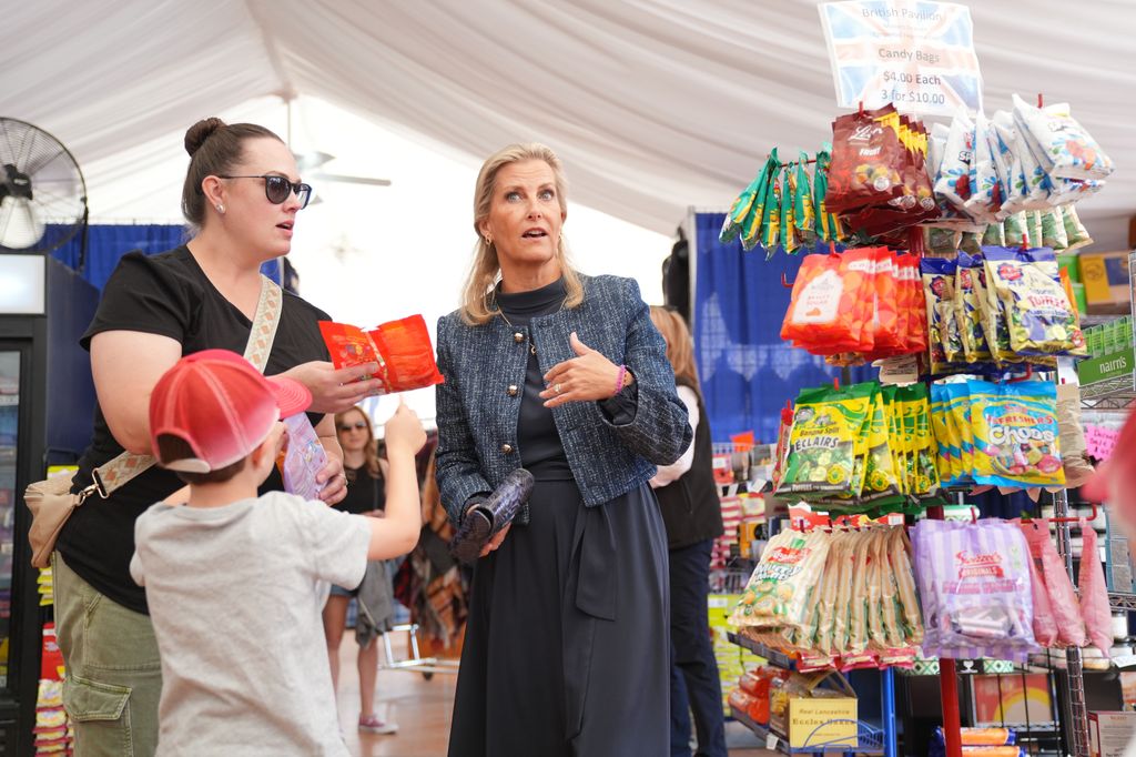 The Duchess of Edinburgh talking with a young boy and his mum beside sweets 