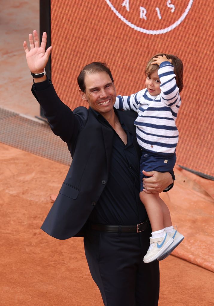 Rafael Nadal carries his son Rafael out on to Court Philippe-Chatrier during a ceremony held in his honour on Day One of the 2025 French Open at Roland Garros on May 25, 2025 in Paris, France.