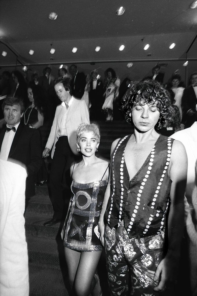 Kylie Minogue wearing a sparkly mini dress and holding hands with Michael Hutchence 