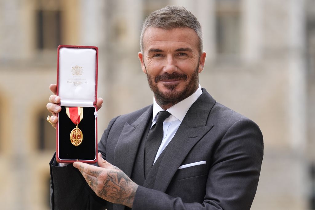 David Beckham memegang medali setelah menjadi seorang ksatria