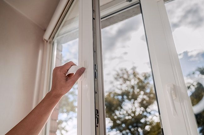 A woman opening a window