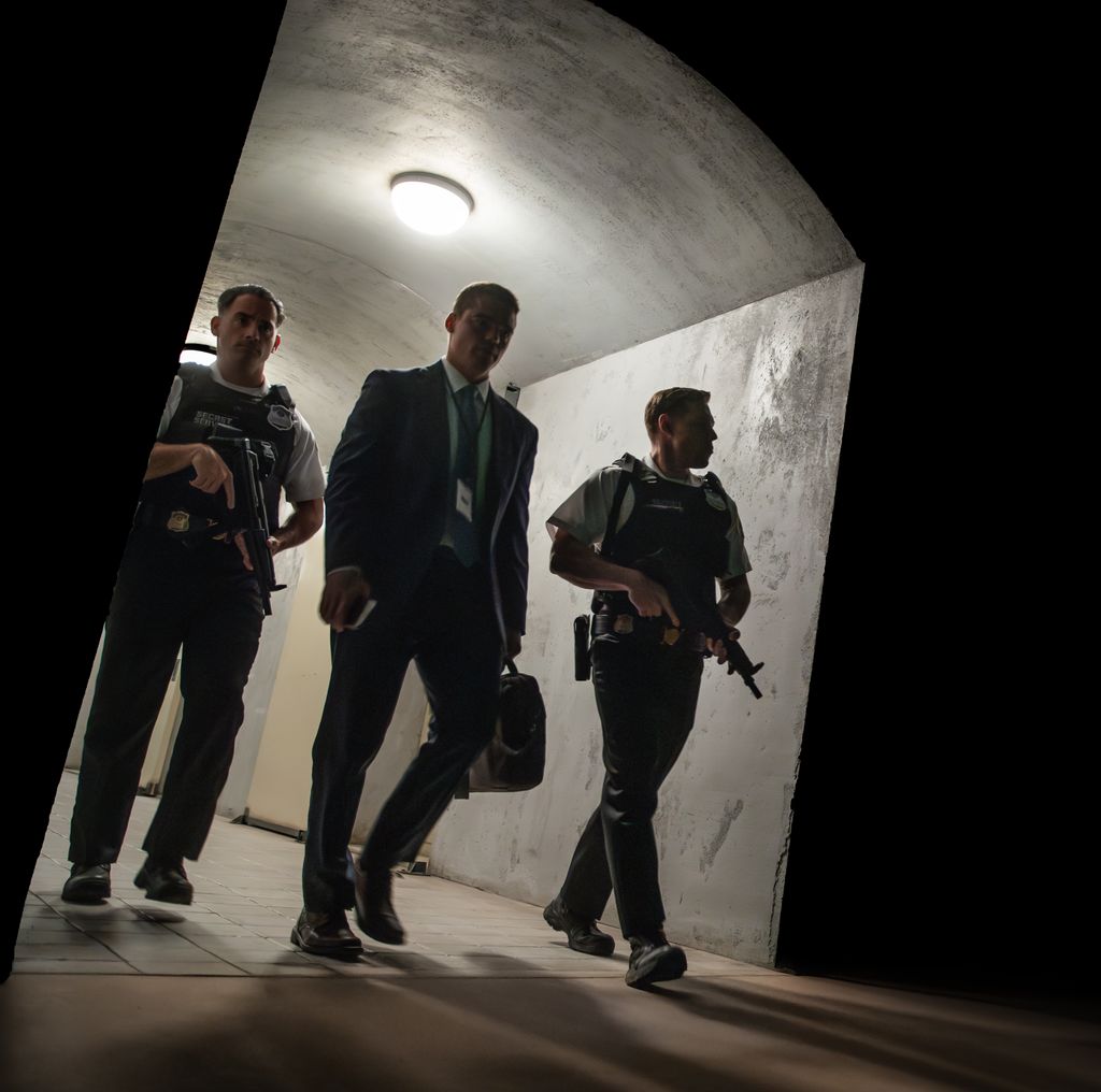 three men walking, two hlding guns