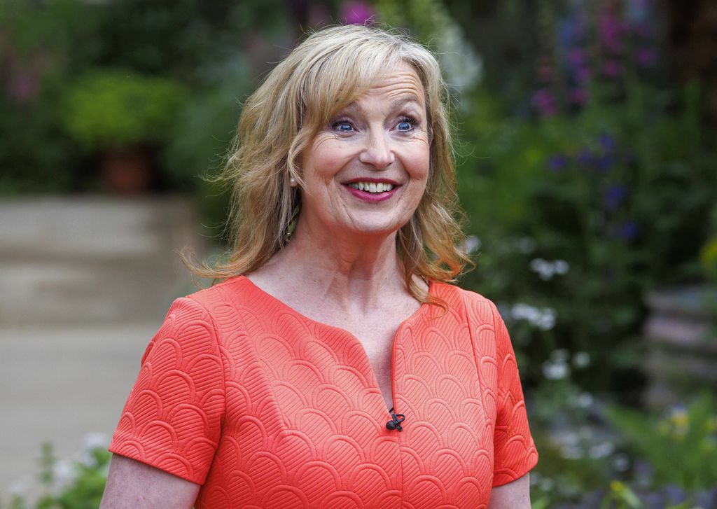 Carol Kirkwood looking excited in an orange dress
